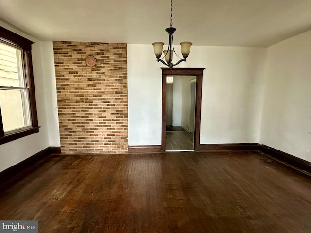 115 Bellevue St, Cumberland, MD 21502 - unfurnished dining area featuring dark wood-style flooring, a chandelier, baseboards, and brick wall