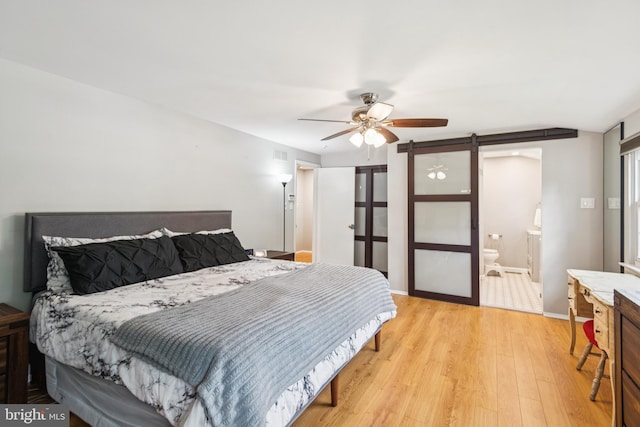 20 Hydra Ln, Sewell, NJ 08080 - bedroom with a barn door, light wood-type flooring, ensuite bath, ceiling fan, and baseboards
