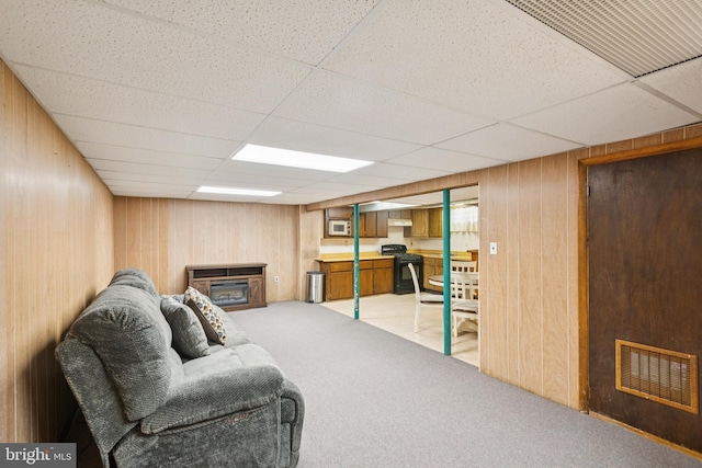20 Hydra Ln, Sewell, NJ 08080 - living room featuring light colored carpet, a paneled ceiling, wooden walls, and a glass covered fireplace