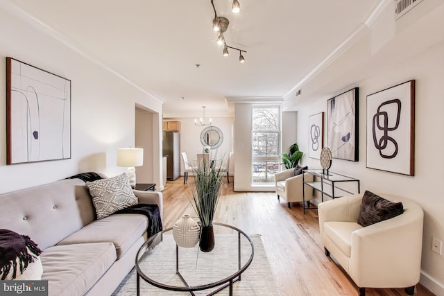 2615 4th St NE Unit 202, Washington, DC 20002 - living area featuring light wood-style floors, ornamental molding, and a chandelier