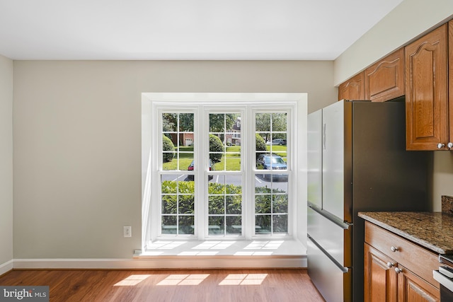 8530 Raglan Rd, Vienna, VA 22182 - kitchen featuring wood finished floors, brown cabinets, freestanding refrigerator, and dark stone countertops