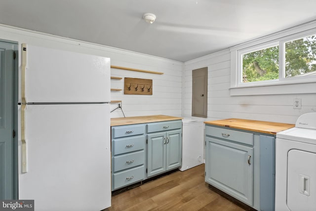 7407 Falmouth St, Springfield, VA 22150 - kitchen featuring freestanding refrigerator, washer / clothes dryer, butcher block counters, dark wood-style floors, and wooden walls