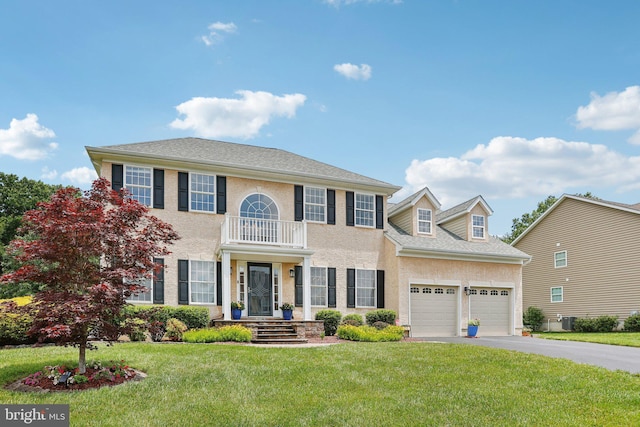 610 Ravenglass Dr, Townsend, DE 19734 - georgian-style home featuring a garage, a front yard, asphalt driveway, and a balcony