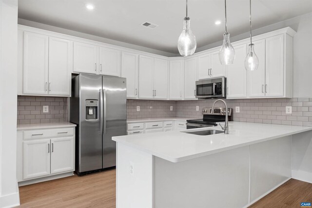 678 Noush Ct Unit A, Charlottesville, VA 22911 - kitchen featuring appliances with stainless steel finishes, light wood finished floors, light countertops, a peninsula, and white cabinetry