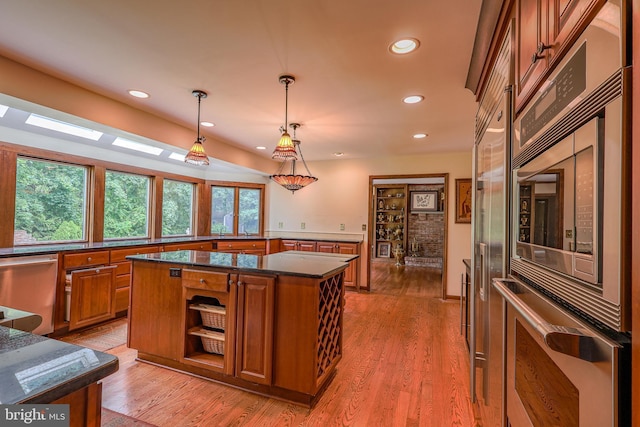 1 Willow Brook Ln, Annandale, NJ 08801 - kitchen featuring brown cabinets, appliances with stainless steel finishes, a kitchen island, light wood-style floors, and pendant lighting