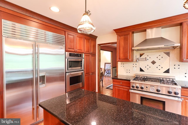 1 Willow Brook Ln, Annandale, NJ 08801 - kitchen with appliances with stainless steel finishes, wall chimney exhaust hood, backsplash, brown cabinetry, and wood finished floors