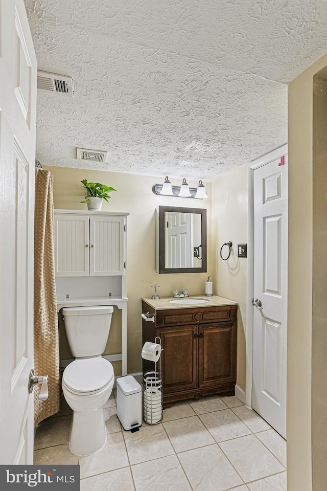7810 Hanover Pkwy Unit 336, Greenbelt, MD 20770 - bathroom featuring vanity, tile patterned flooring, toilet, a textured ceiling, and baseboards