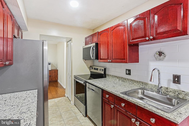 7810 Hanover Pkwy Unit 336, Greenbelt, MD 20770 - kitchen with appliances with stainless steel finishes, a sink, reddish brown cabinets, and backsplash