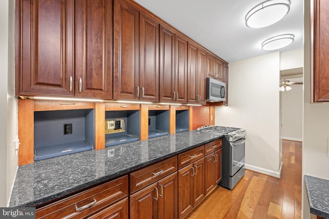 3701 Connecticut Ave NW Unit 312/326, Washington, DC 20008 - kitchen featuring stainless steel appliances, light wood finished floors, dark stone counters, and baseboards