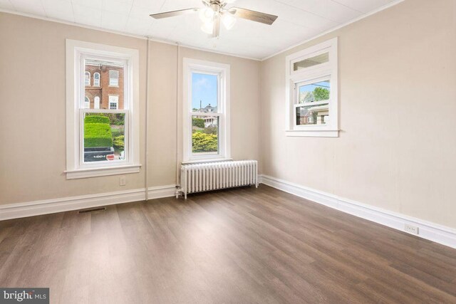 208 W N St, Waynesboro, PA 17268 - unfurnished room featuring radiator, dark wood-style flooring, a ceiling fan, crown molding, and baseboards