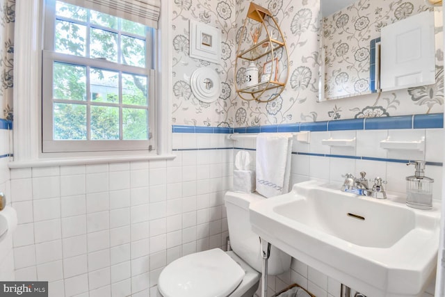 4212 Ingomar St NW, Washington, DC 20015 - bathroom featuring wallpapered walls, toilet, healthy amount of natural light, a sink, and a wainscoted wall