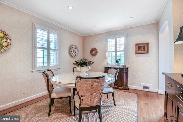 4212 Ingomar St NW, Washington, DC 20015 - dining space featuring wood finished floors, ornamental molding, arched walkways, baseboards, and wallpapered walls
