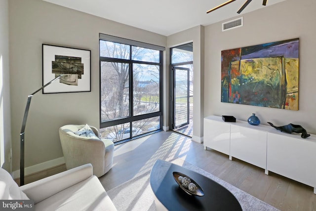 525 Water St SW Unit 319, Washington, DC 20024 - living room featuring wood finished floors, a ceiling fan, and baseboards