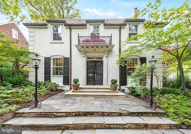 7006 Meadow Ln, Chevy Chase, MD 20815 - view of front facade with a balcony, a chimney, and brick siding