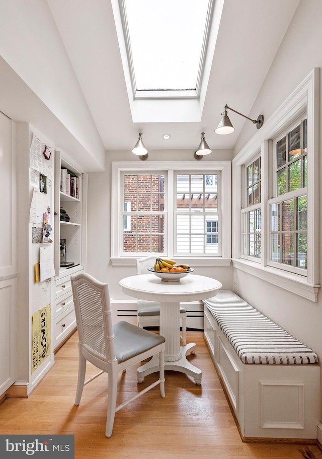 7006 Meadow Ln, Chevy Chase, MD 20815 - dining area with breakfast area, lofted ceiling, light wood-type flooring, a skylight, and a baseboard heating unit