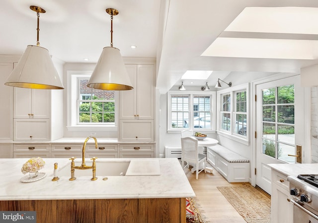 7006 Meadow Ln, Chevy Chase, MD 20815 - kitchen with healthy amount of natural light, a skylight, light wood-style flooring, and pendant lighting