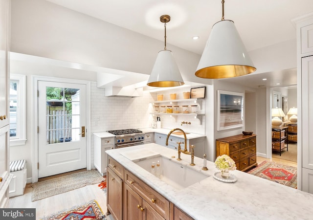 7006 Meadow Ln, Chevy Chase, MD 20815 - kitchen featuring a sink, light wood-style flooring, tasteful backsplash, light stone countertops, and pendant lighting