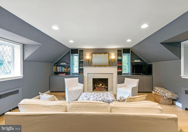 7006 Meadow Ln, Chevy Chase, MD 20815 - living area featuring radiator, lofted ceiling, wood finished floors, a lit fireplace, and recessed lighting