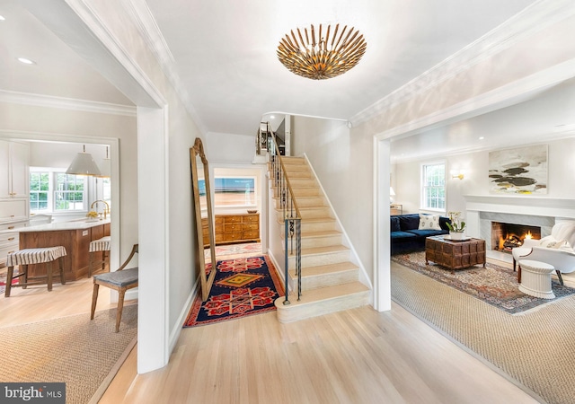 7006 Meadow Ln, Chevy Chase, MD 20815 - staircase featuring wood finished floors, plenty of natural light, a lit fireplace, baseboards, and crown molding