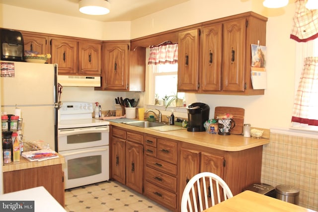 4520 Strahle St, Philadelphia, PA 19136 - kitchen featuring under cabinet range hood, white appliances, and brown cabinetry