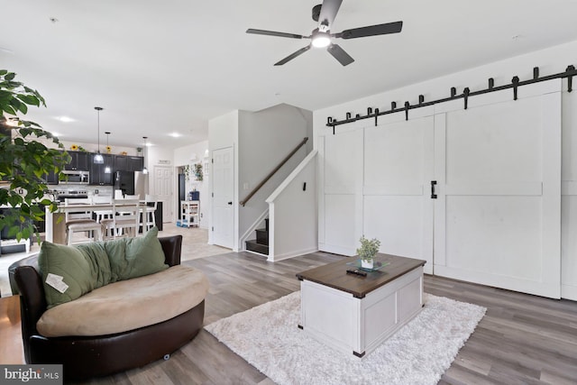 1408 Canopy Ln, Odenton, MD 21113 - living room with a barn door, wood finished floors, ceiling fan, and stairway