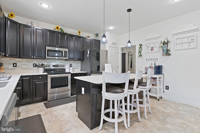1408 Canopy Ln, Odenton, MD 21113 - kitchen with appliances with stainless steel finishes, backsplash, a breakfast bar area, light countertops, and pendant lighting