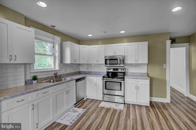 937 Fern Ave, Reading, PA 19607 - kitchen with appliances with stainless steel finishes, a sink, light wood-style flooring, white cabinetry, and recessed lighting