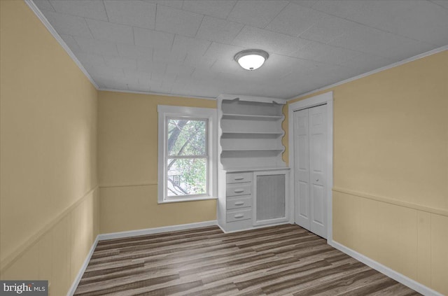 937 Fern Ave, Reading, PA 19607 - unfurnished bedroom with ornamental molding, dark wood-style floors, wainscoting, a closet, and a decorative wall