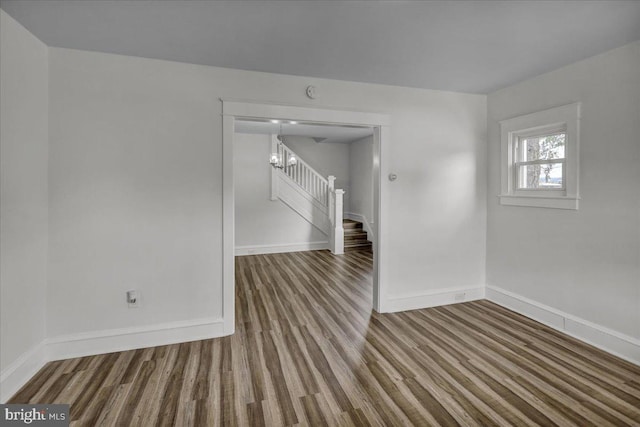 937 Fern Ave, Reading, PA 19607 - spare room with wood finished floors, stairway, baseboards, and a chandelier