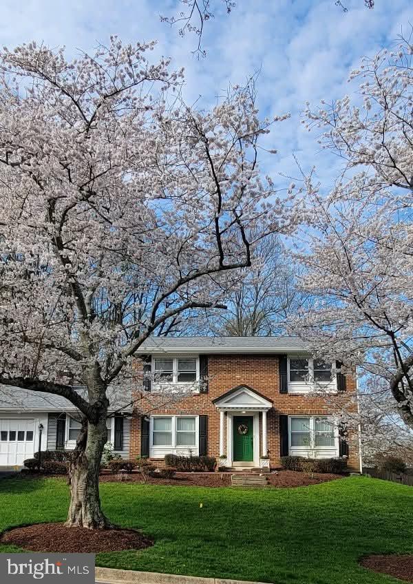18924 Tributary Ln, Gaithersburg, MD 20879 - view of front of home featuring brick siding, a front yard, and a garage