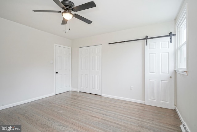 26 Jefferson Dr, Clementon, NJ 08021 - unfurnished bedroom with wood finished floors, a barn door, baseboards, and ceiling fan