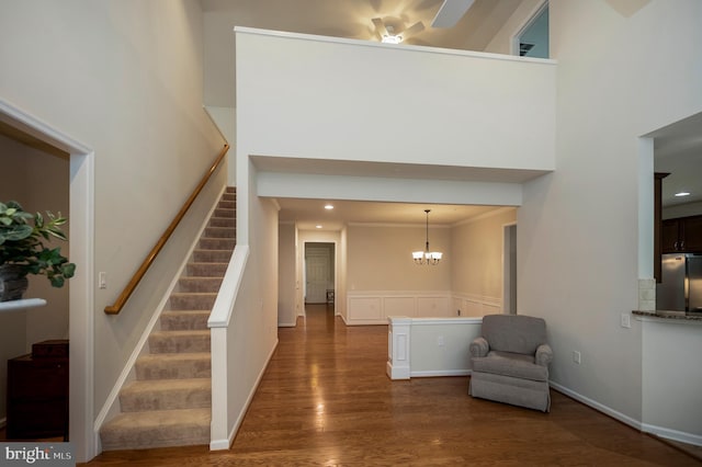 43 Battery Point Dr, Fredericksburg, VA 22406 - foyer entrance with dark wood-type flooring, stairs, a chandelier, a wainscoted wall, and a high ceiling