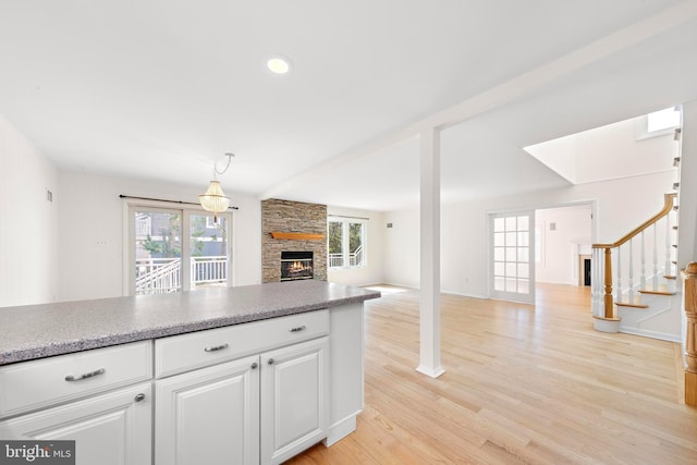1131 Long Beach Blvd, Long Beach Township, NJ 08008 - kitchen featuring a fireplace, white cabinets, light wood-style flooring, open floor plan, and pendant lighting