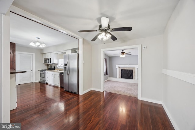 1013 S Scott Ave, Lindenwold, NJ 08021 - kitchen featuring appliances with stainless steel finishes, a sink, white cabinets, a fireplace, and dark wood-style flooring