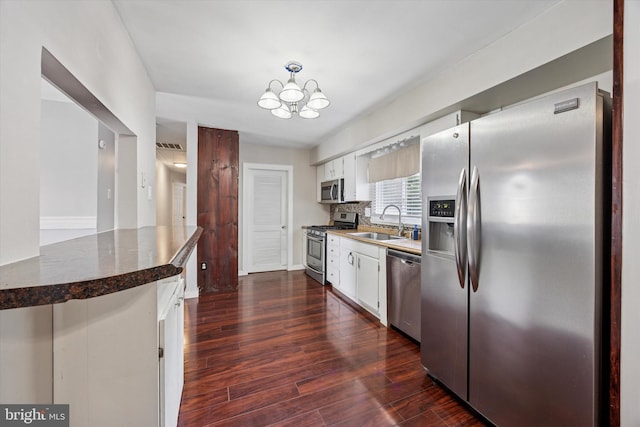 1013 S Scott Ave, Lindenwold, NJ 08021 - kitchen with stainless steel appliances, a sink, white cabinets, dark wood-type flooring, and a chandelier
