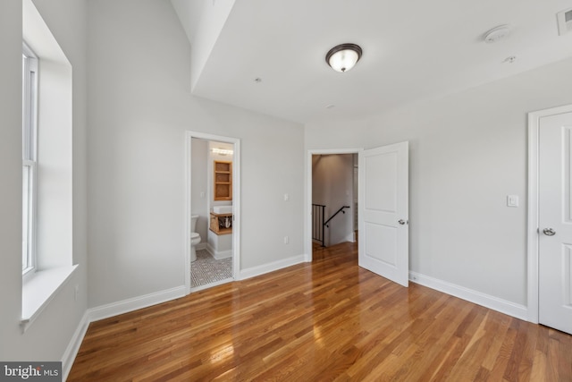 141 NE V St NE, Washington, DC 20002 - unfurnished bedroom with light wood-type flooring, baseboards, and ensuite bathroom