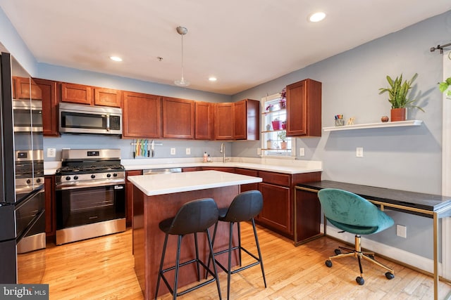 3111 Tilden Dr, Baltimore, MD 21211 - kitchen with stainless steel appliances, light wood-style floors, a sink, a kitchen breakfast bar, and light countertops