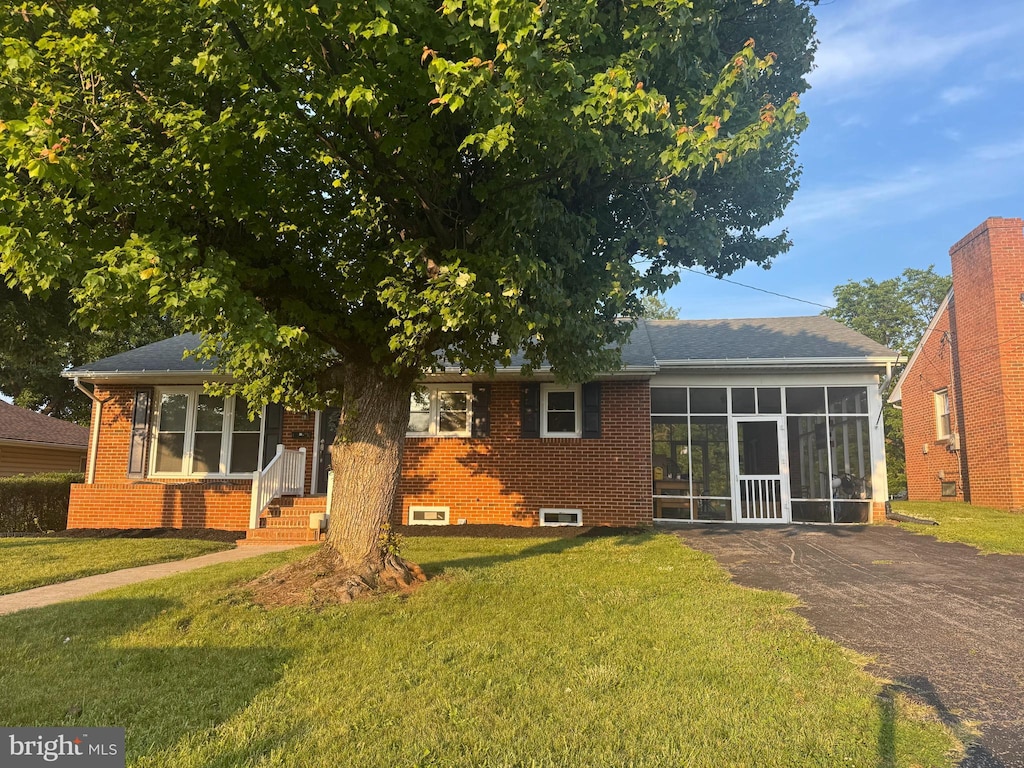 117 Washington Ave, Front Royal, VA 22630 - rear view of property featuring a lawn, brick siding, and a sunroom