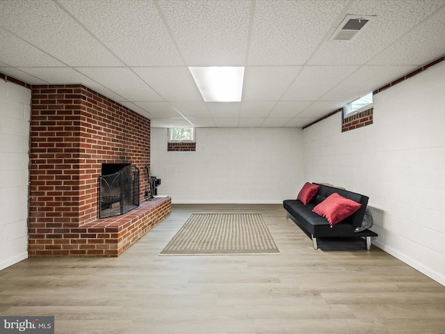 117 Washington Ave, Front Royal, VA 22630 - unfurnished room featuring a paneled ceiling, wood finished floors, a brick fireplace, and concrete block wall