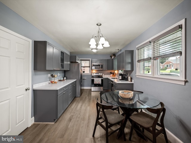 117 Washington Ave, Front Royal, VA 22630 - kitchen featuring stainless steel appliances, gray cabinetry, a chandelier, light countertops, and healthy amount of natural light