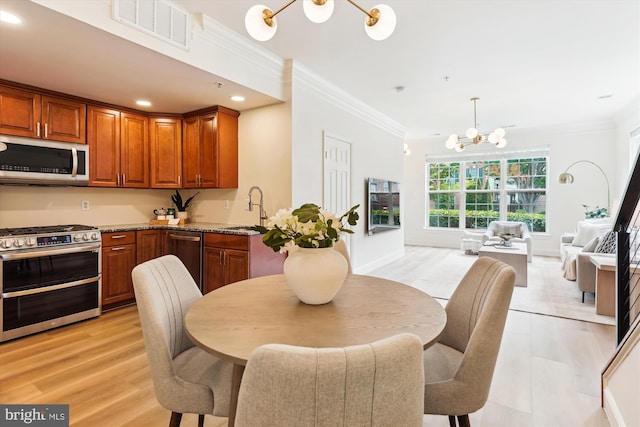 604 Highland Ridge Ave Unit 100, Gaithersburg, MD 20878 - kitchen featuring appliances with stainless steel finishes, a chandelier, crown molding, brown cabinets, and recessed lighting
