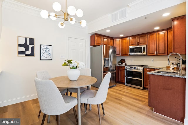 604 Highland Ridge Ave Unit 100, Gaithersburg, MD 20878 - kitchen with stainless steel appliances, crown molding, a chandelier, light wood-type flooring, and brown cabinets