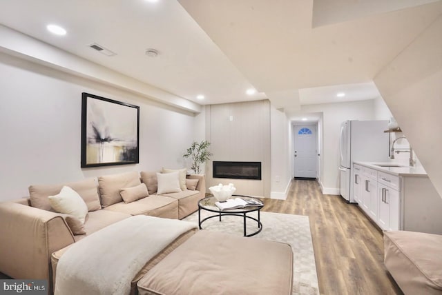2221 15th St NE, Washington, DC 20018 - living room with light wood finished floors, recessed lighting, a glass covered fireplace, and baseboards
