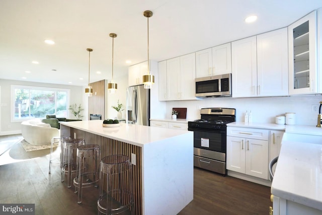 2221 15th St NE, Washington, DC 20018 - kitchen featuring stainless steel appliances, dark wood finished floors, a kitchen bar, white cabinetry, and a center island