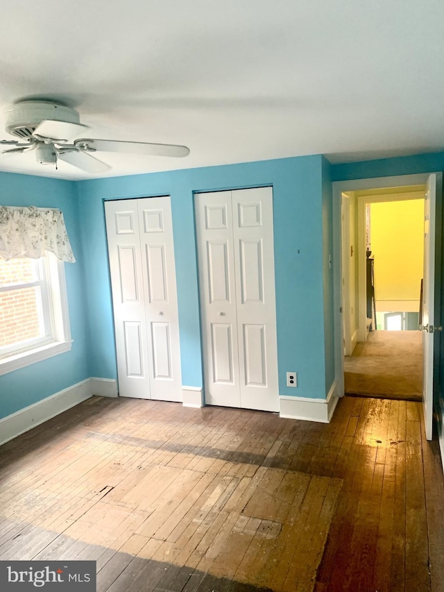 42 E 5th St, New Castle, DE 19720 - unfurnished bedroom with multiple closets, hardwood / wood-style floors, and ceiling fan