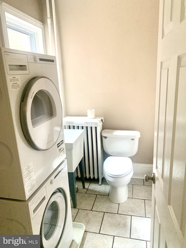 42 E 5th St, New Castle, DE 19720 - bathroom with stacked washing machine and dryer, radiator, and tile patterned floors
