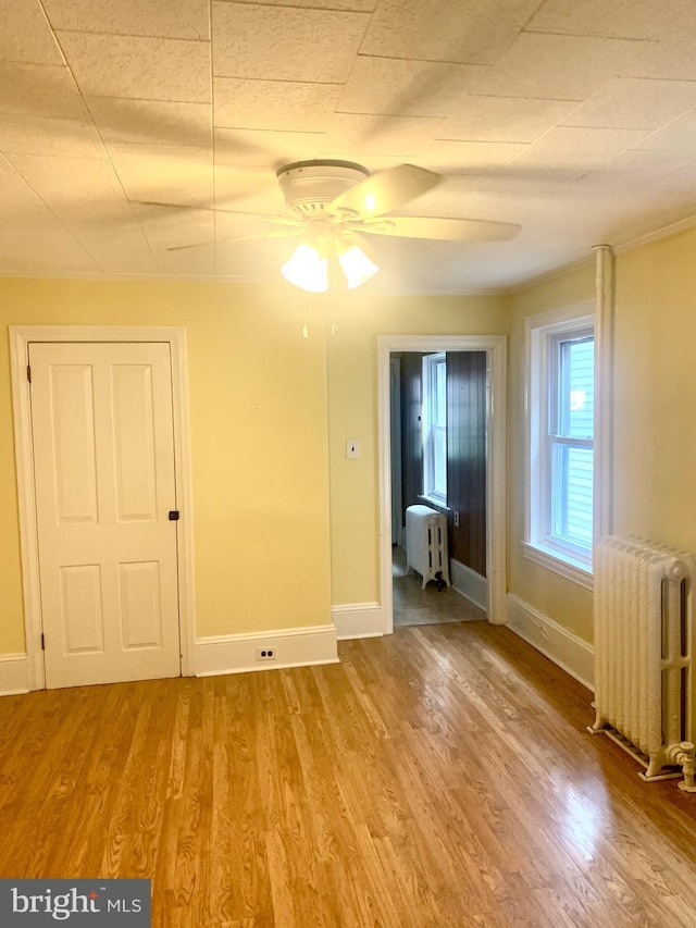 42 E 5th St, New Castle, DE 19720 - spare room with radiator heating unit, a ceiling fan, and wood finished floors