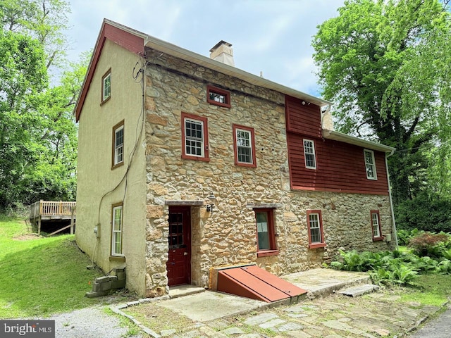 3709 E Fisherville Rd, Downingtown, PA 19335 - back of property featuring stone siding, a chimney, stucco siding, and a deck