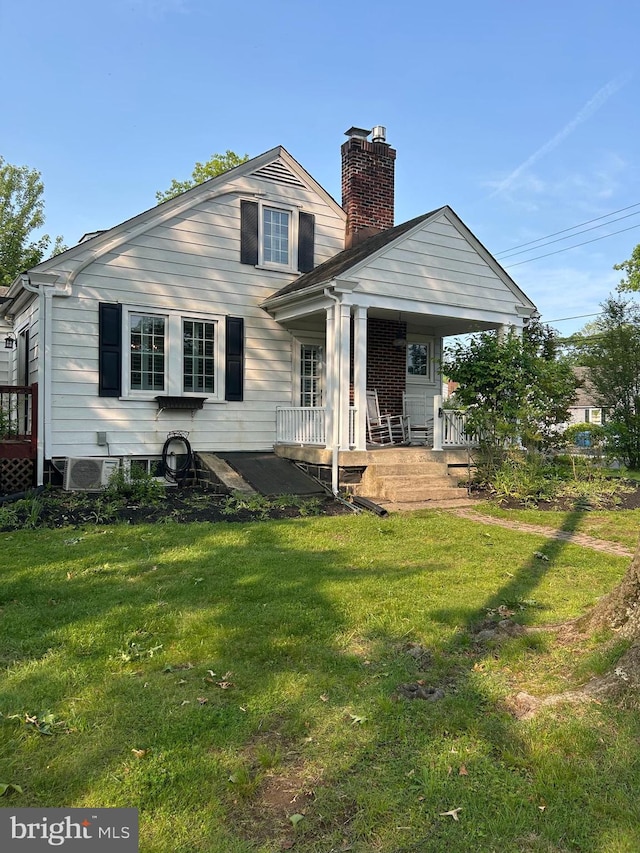802 E Prospect Ave, North Wales, PA 19454 - rear view of property featuring a chimney, a lawn, and covered porch