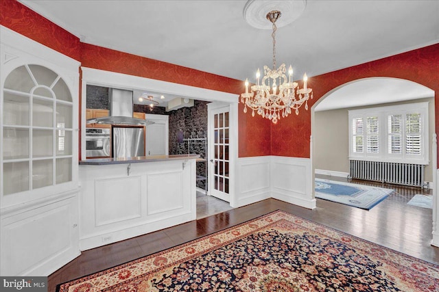 802 E Prospect Ave, North Wales, PA 19454 - unfurnished dining area with a chandelier, arched walkways, wainscoting, wood finished floors, and a decorative wall